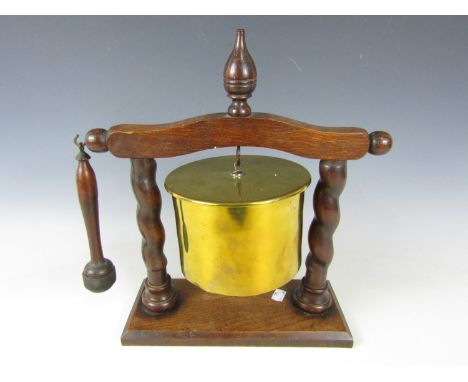 A First World War 15 cm German artillery shell case trench art dinner gong, on a twist turned oak stand, 38 cm 