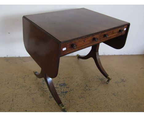 A Regency mahogany sofa table, having a rounded rectangular top with reeded edge, the friezes ebony banded and incorporating 