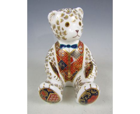 A Royal Crown Derby Collectors' Guild bone china Teddy bear with blue bow-tie paperweight, with gold stopper, 11.5 cm