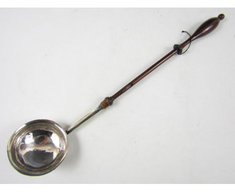 An 18th Century white metal toddy ladle with baluster-turned wooden handle, the bowl bearing engraved marriage marks