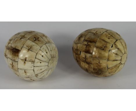 A pair of carved sectional bone eggs, 14cm