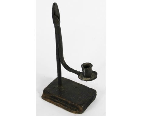 An 18th century wrought iron rush nip light, on stained wood base, 29cm