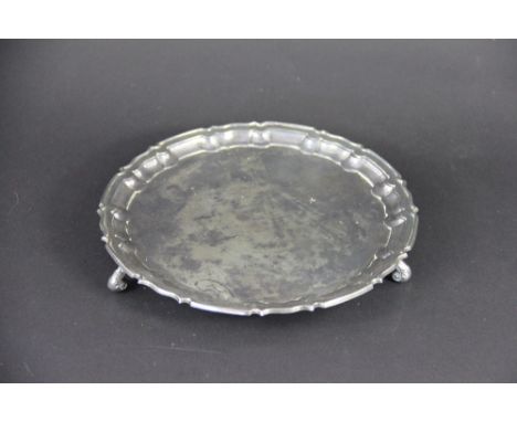 A silver salver William Hutton & Sons Ltd, Sheffield 1934, of circular form, with pie crust rim and raised on three scroll fe