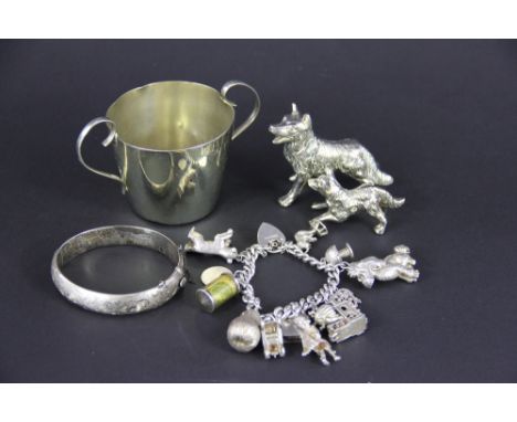 A silver charm bracelet with padlock clasp and suspending various charms including; a pear, a bear, a poodle, a toadstool etc