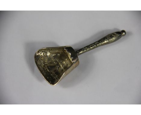A Continental silver caddy shovel, import mark for Chester 1909, the bowl embossed with a milkmaid with scroll cast handle, 8