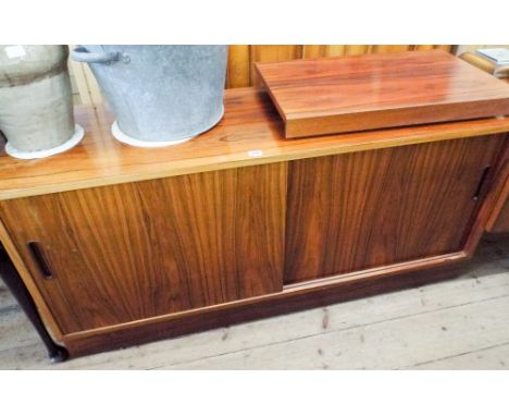 A 1970's Danish sideboard with a blonde wood interior and plywood back. It is fitted with sliding doors, fitted with a swivel