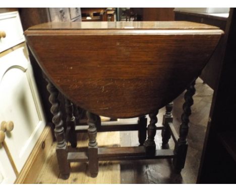 An oval oak gate legged table on barley twist legs, 2'6" wide 