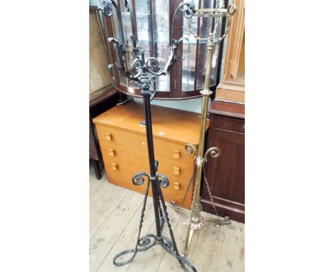 A brass adjustable lamp standard and a wrought iron lamp standard