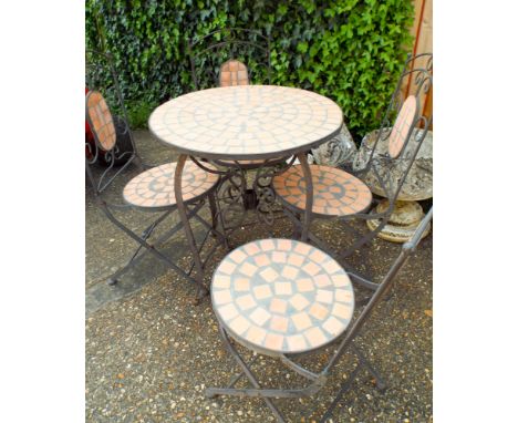 A circular iron framed garden table with tile effect top and four matching folding chairs 