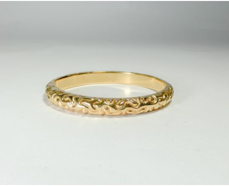 A ladies 9ct yellow gold hinged bangle with invisible clasp and embossed decoration, gross weight 12g 
