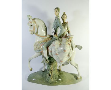 A large Lladro figure group fulgencio garcia of a couple astride a white station on a naturalistic base. 43cm high and issued