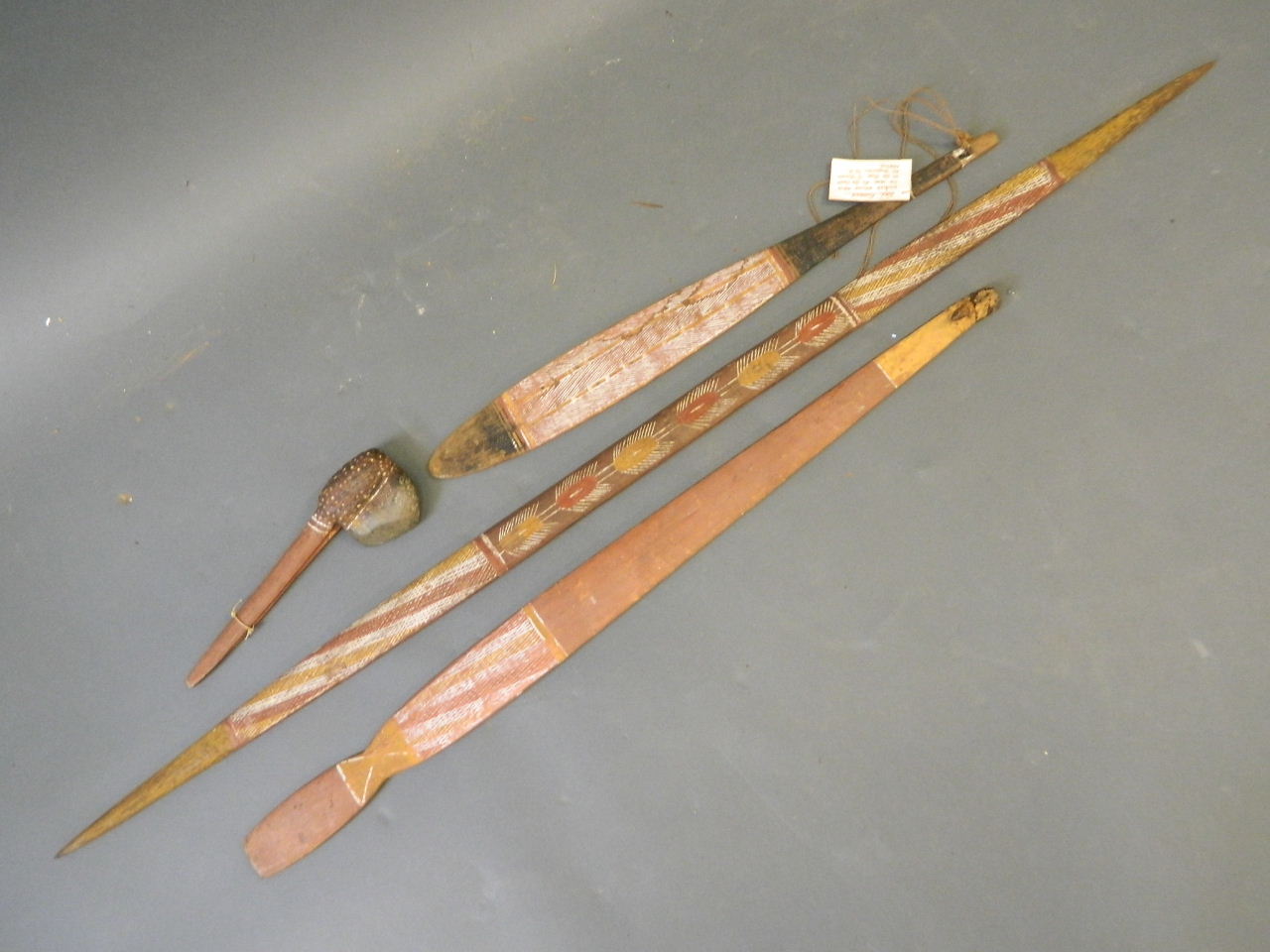An Aboriginal woomera and spear, together with a matching bullroarer