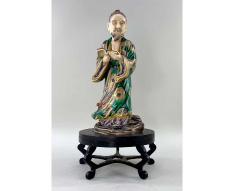 JAPANESE SATSUMA EARTHENWARE FIGURE OF A MONK, Meiji Period, wearing green and gilt mon robe with aubergine sash, holding an 