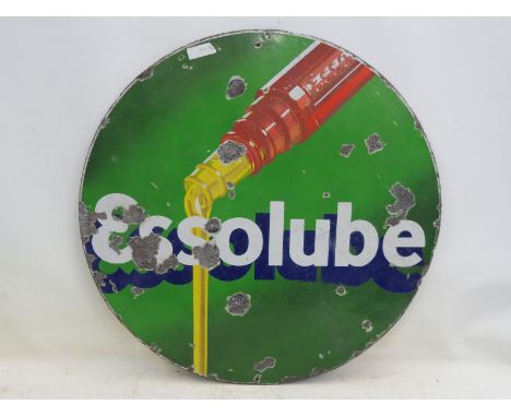 An Essolube circular enamel sign depicting oil pouring from a bottle, 30" diameter.