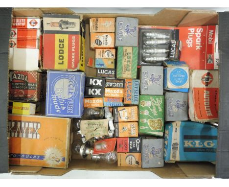 A box of lamp bulb packaging and spark plug boxes, some with contents.