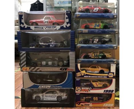12 various boxed die cast model racing cars of scale 1:18 (5) &amp; 1:24 (7). 