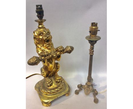 A gilt composition table lamp modelled as a Heraldic seated lion, 38cm high, together with a brass Renaissance style lamp, 32