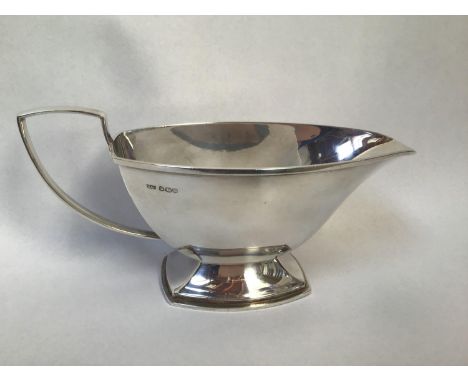 A silver sauce boat with angular mid section, shaped handle, hallmarked Sheffield, 1938, maker's mark 'W&amp;G', 7.89 ozt 