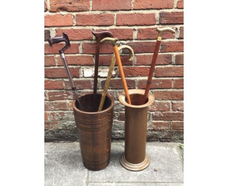 An Arts &amp; Crafts hammered copper stick / umbrella stand, 49cm high, together with a carved wooden stick / umbrella stand 