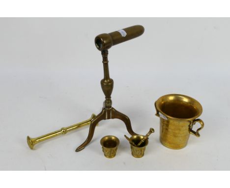 A 19th century brass goffering / tally iron raised on tripod serpentine supports, 23 cm (h) and brass mortars and pestles. [W