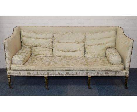 A Hepplewhite period three seater sofa, circa 1790-1810, upholstered in floral green silk, with loose cushions, raised on eig