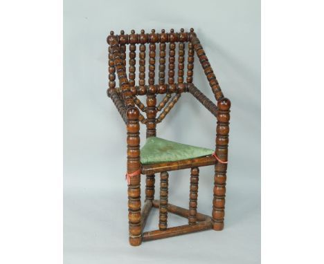 A Victorian bobbin turned carver chair, with a triangular shaped seat, raised on turned legs united by stretchers.