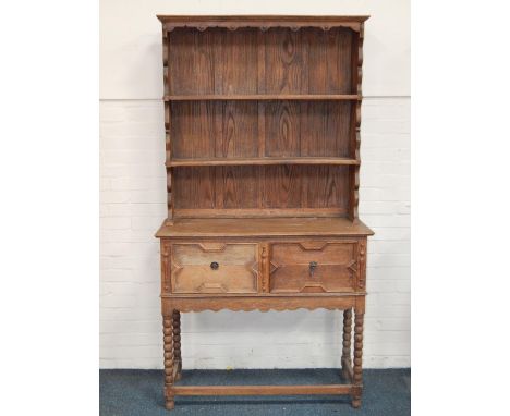 An early 20thC oak dresser, the two shelf Delft rack over a pair of deep frieze drawers, raised on bobbin turned legs united 