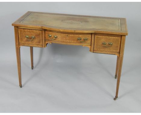 An Edwardian mahogany and satinwood crossbanded lady's writing table, the tooled leather bow front over one long and two deep