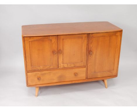 An Ercol elm sideboard, with two doors over a frieze drawer, flanked to the right by a further cupboard enclosing a cutlery s