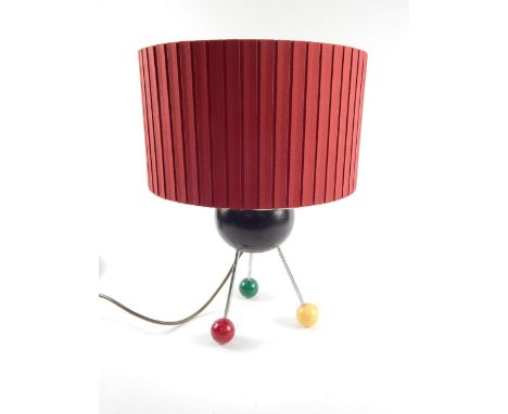 A 1950's atomic table lamp formed of a Jacques 'Jaquelite' lignum vitae bowl, raised on three steel rods with green, yellow a