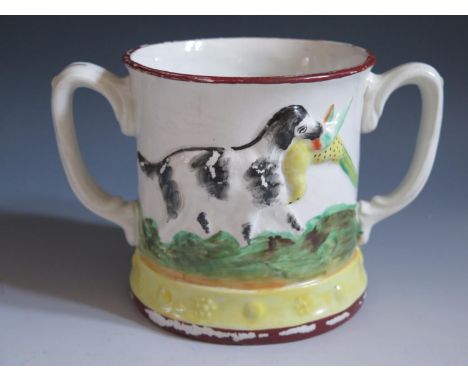 A Nineteenth Century Loving Cup with frog inside and decorated with relief scenes of pointer and spaniel, 14cm, hairline to r
