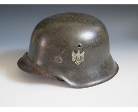 A WWII German Army SD Helmet, rim stamped 1753, with leather chin strap 