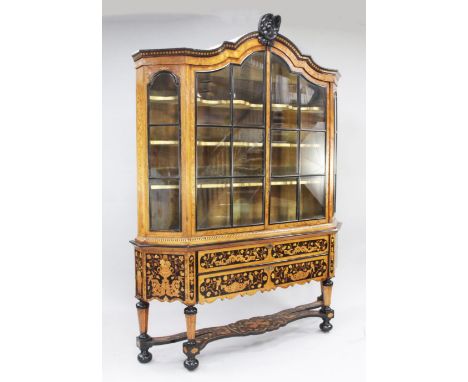 A 19th century Dutch marquetry inlaid bookcase, the arched top with glazed panel doors over two drawers, on tapering hexagona