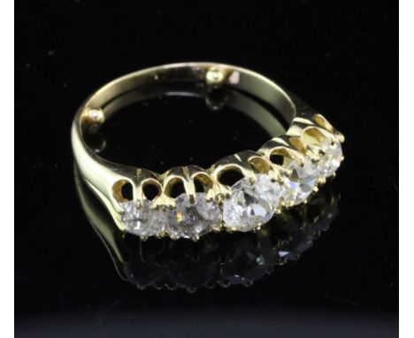 An early 20th century unmarked gold and graduated five stone half hoop ring, size K.