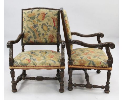 A pair of Louis XVI style carved and stained beech open armchairs, with tapestry upholstered backs and seats with acanthus le
