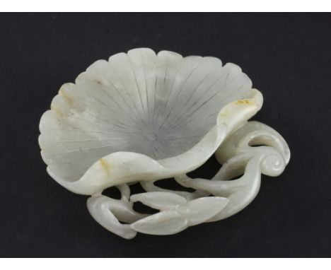 A Chinese pale celadon jade 'lotus leaf' brush washer, the bowl formed from the curling leaf, the handle carved in openwork w