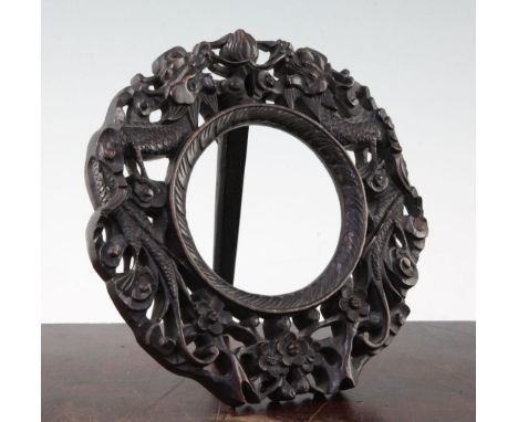A Chinese rosewood circular easel photograph frame, late 19th century, the border carved and pierced with confronting dragons