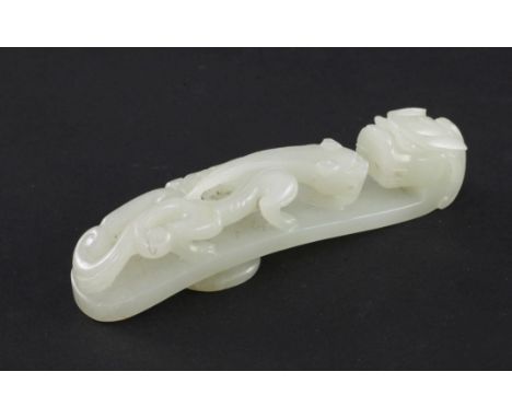 A Chinese pale celadon jade 'dragon' belt hook, 18th / 19th century, carved in high relief and openwork with a chi-dragon, wi