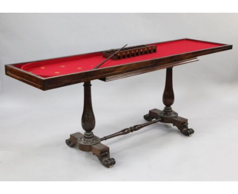 An early 19th century rosewood folding bagatelle table, with baluster turned ends united by turned stretcher, on scroll feet,