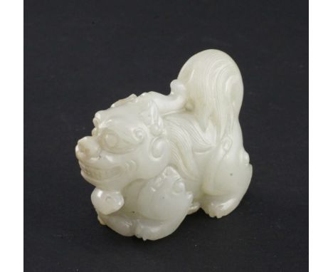 A Chinese pale celadon jade group of a lion-dog and a snake, in standing pose, the stone of even tone with some brown veining