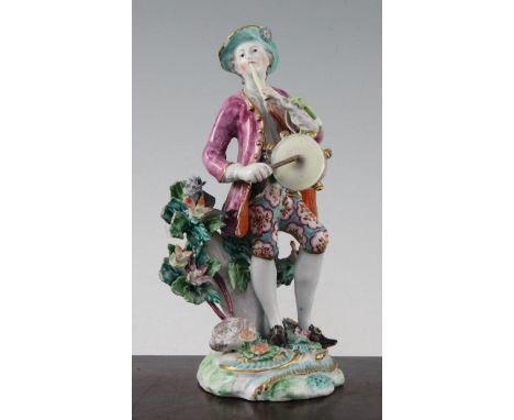 A Bow figure of a musician, c.1758, modelled playing a pipe and tambour standing beside a flowering tree, on a moulded base, 