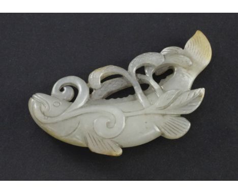 A Chinese pale celadon and russet jade carving of a fish, 19th century, the fish swimming amid millet, the carver using small