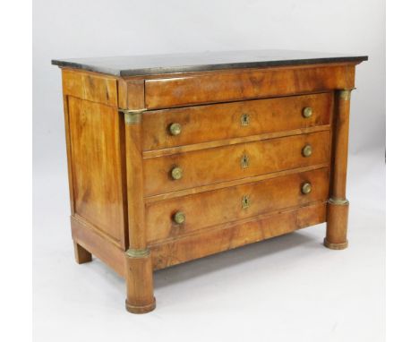 A 19th century French walnut marble top commode, fitted with four drawers flanked by cylindrical pillars with engine turned g