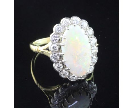 A gold, white opal and diamond oval cluster ring, size L.