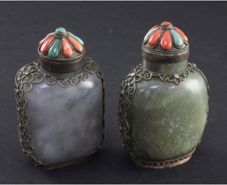 Two Tibetan style mounted jade snuff bottles, 1880-1920, the first of mottled grey jade with a russet skin to the flat revers