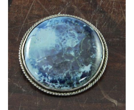 A Ruskin pottery silver mounted brooch, the slightly domed circular plaque decorated in blue, pale turquoise and green glazes