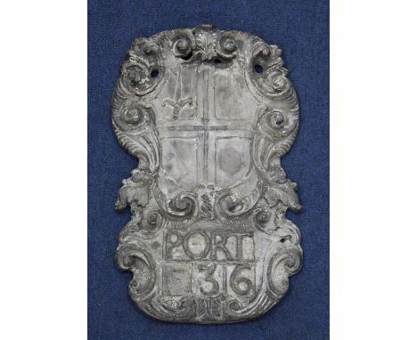 A late 17th century cartouche shape armorial wall plaque, modelled as quartered shield with sword to upper left quarter, simi