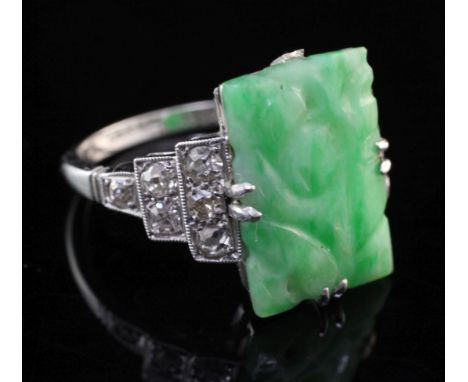 A mid 20th century 18ct white gold and platinum diamond and jadeite ring, with diamond set stepped shoulders and jade plaque 