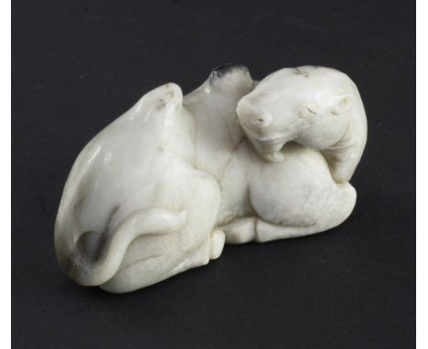 A Chinese white and black jade carving of a recumbent Bactrian camel, in Song dynasty style, his head turned backward to the 