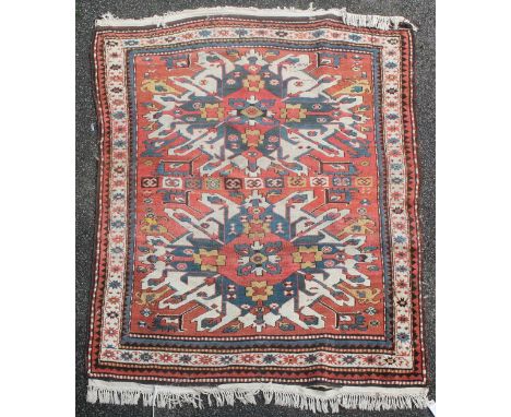 A Kazak rug, with two hooked geometric motifs on an orange ground, with three row border, 6ft by 4ft 10in.